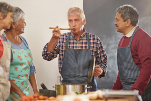 A group of senior friends watching as one tastes food with a ladle